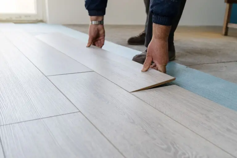 Close up of worker installing luxury vinyl plank flooring