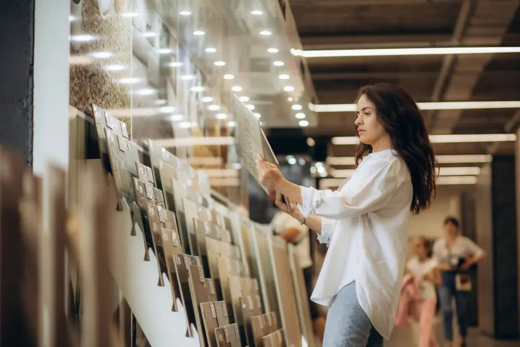 Woman comparing tile flooring samples in showroom