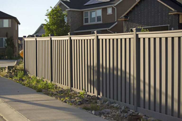 Greige vinyl privacy fence around yard.