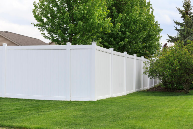 Contemporary white vinyl fence surrounding yard